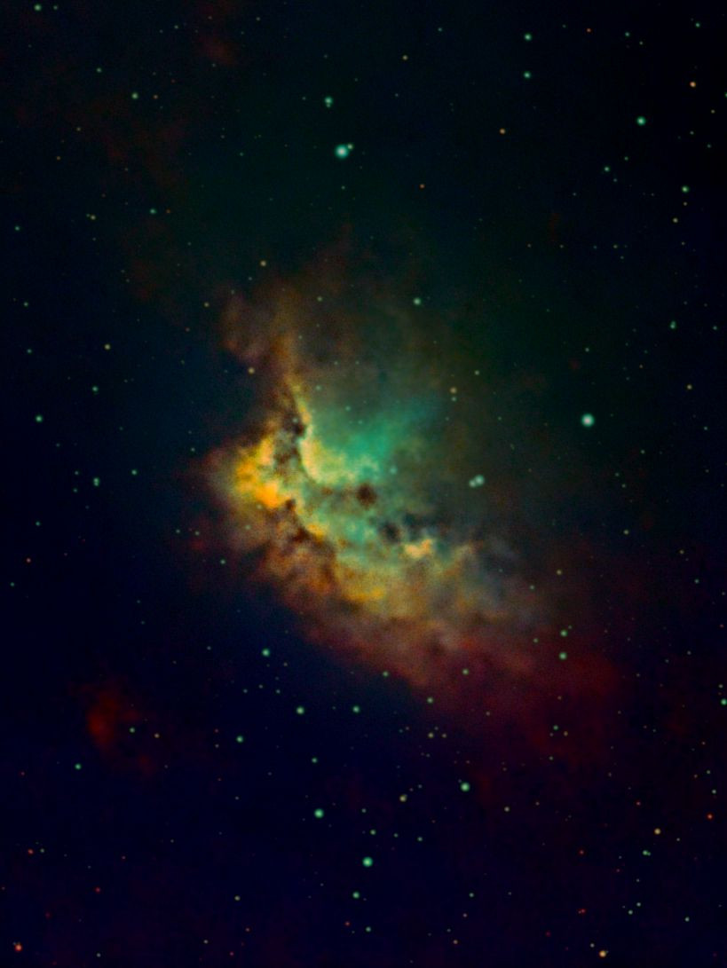 The Wizard Nebula (NGC 7380) in teal and amber against a dark star field